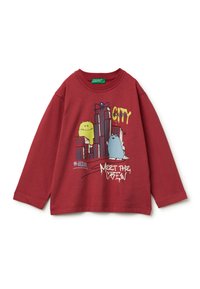 Rode sweatshirt met lange mouwen, versierd met cartoonmonsters en graphics van stadsgebouwen, met de tekst "CITY" en "MEET THE CREW" in kleurrijke druk.