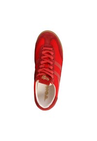 Zapatilla roja con upper de ante y textil, puntera redonda, cierre con cordones, y suela de goma. Presenta tres franjas horizontales en los laterales.