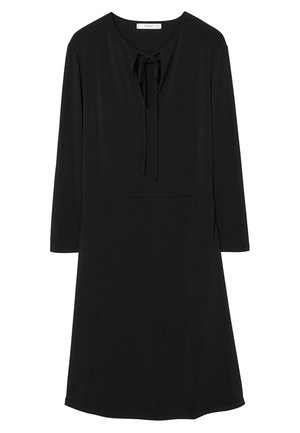 Czarna sukienka z długim rękawem do kolan, z okrągłym dekoltem i wiązaniem z przodu, o prostym kroju, wykonana z gładkiej tkaniny.