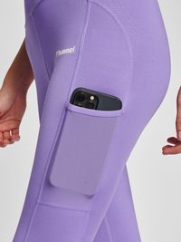 Jasnofioletowe legginsy z boczną kieszenią na telefon, wykonane z elastycznego materiału z teksturowanymi akcentami i logo marki.