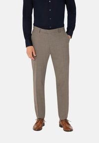 Beige maßgeschneiderte Hosen mit strukturiertem Finish, flachem Bund und Seitentaschen. Getragen mit einem dunklen Hemd mit Knöpfen und braunen Schuhen.