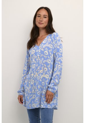 Tunic azzurro chiaro con motivo floreale, scollo a V e maniche lunghe. Realizzata in tessuto leggero con una vestibilità rilassata e spacco laterale.