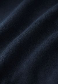 Tessuto blu navy scuro con una texture liscia e una lucentezza sottile, che mostra pieghe delicate e un motivo a maglia uniforme.