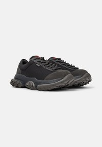 Black and gray hiking shoes with thick soles and textured fabric, featuring black laces and a small red logo on the tongue.