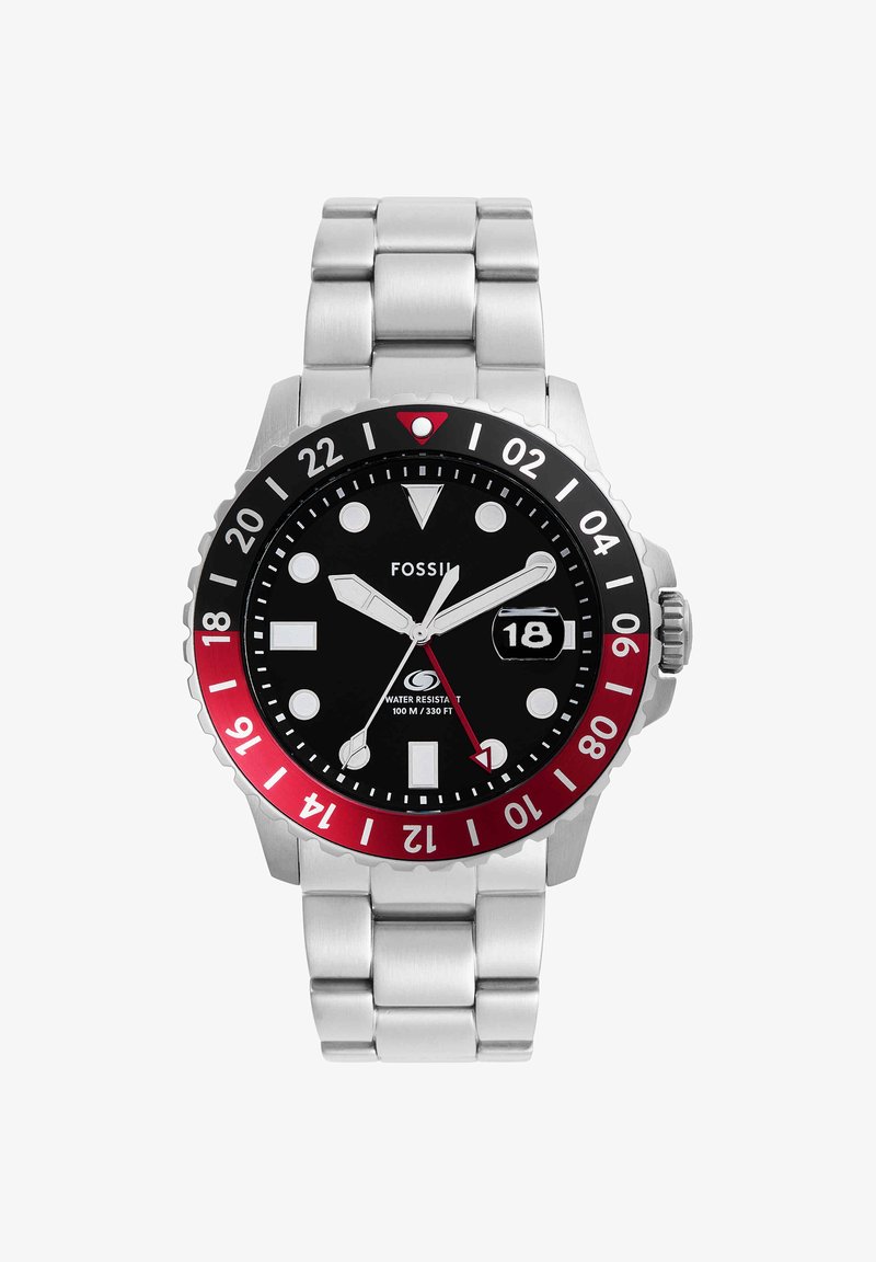 Montre-bracelet Fossil en acier inoxydable avec lunette noire et rouge, cadran noir, aiguilles lumineuses, guichet date affichant 18, et étanchéité jusqu’à 100 m.