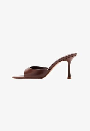 Mules ouvertes marron à talons avec une finition lisse et brillante. Présentent un design courbé et un talon haut et fin pour une silhouette élégante.
