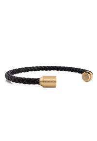 Black braided leather bracelet with two gold-tone metal accents; one features engraved text and the other has a lotus emblem.