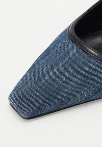 Δερμάτινα παπούτσια με μυτερή μύτη από τζιν με navy blue υφή, που διαθέτουν μαύρη δερμάτινη επένδυση κατά μήκος του επάνω ανοίγματος και μαλακό εσωτερικό φόδρες.