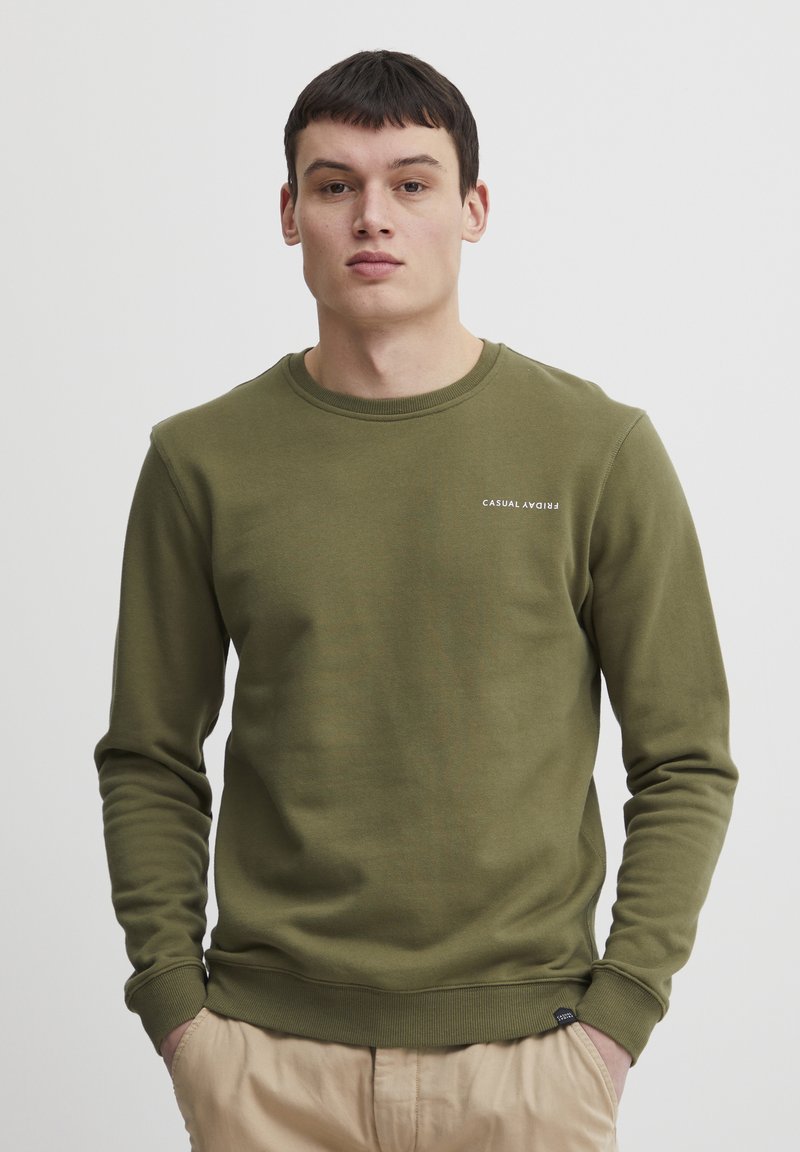 O sweatshirt verde oliv cu guler rotund, manșete ribbed și un mic logo "CASUAL" pe piept. Material moale, texturat.