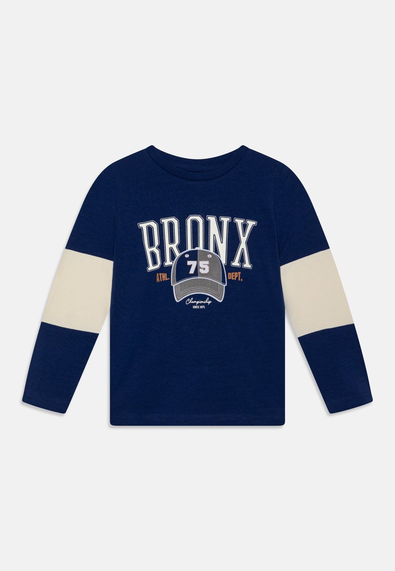 Camicia a maniche lunghe blu navy con accenti crema, presenta la grafica "BRONX 75" in bianco e grigio. Materiale in cotone morbido, stile colletto rotondo.