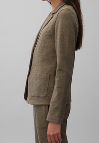 Hnědý kostkovaný blazer s jedním kapsou, klopovými límci a přiléhavým střihem, vyrobený z texturované látky.
