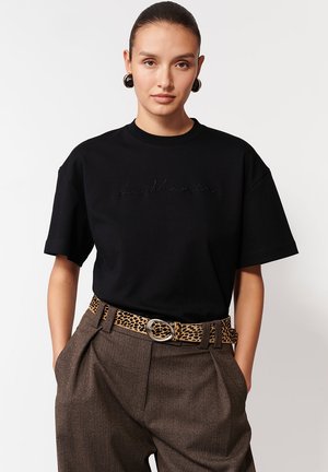 Czarny t-shirt z krótkim rękawem z haftowanym logo "La Maria", zestawiony z brązowymi spodniami o wysokim stanie i paskiem w cętki.