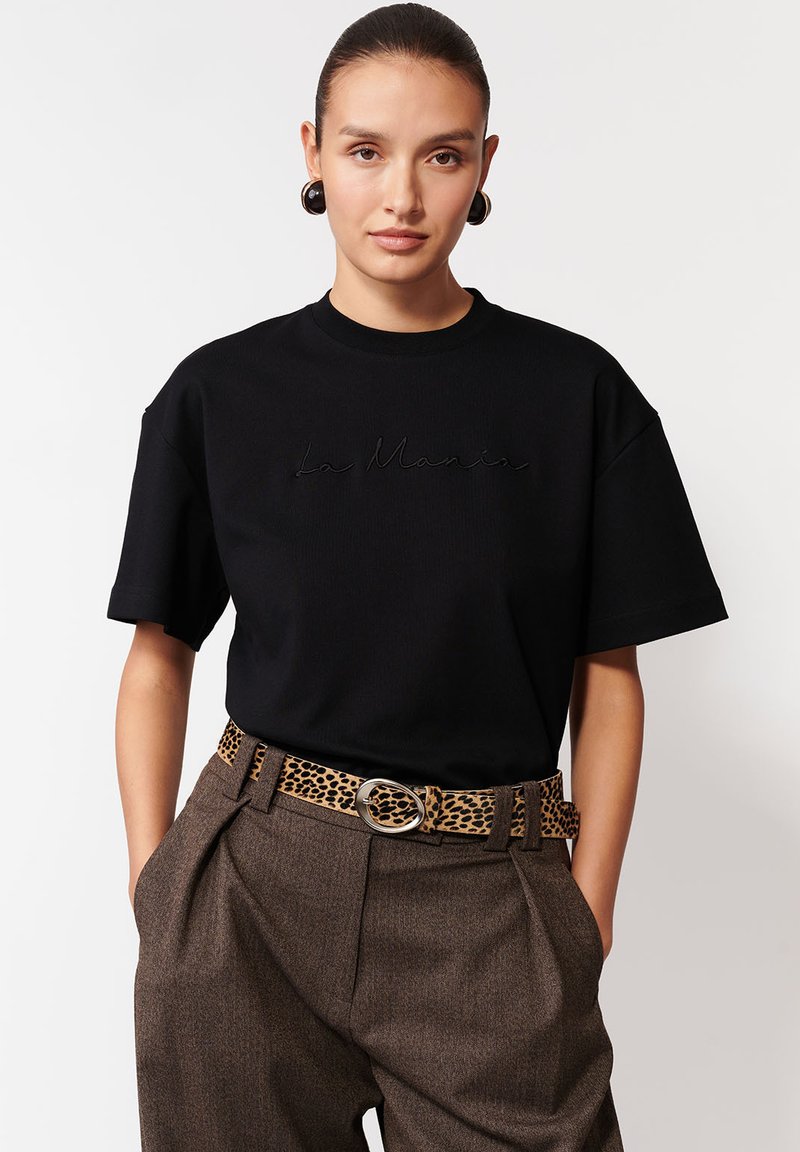 Czarny t-shirt z krótkim rękawem z haftowanym logo "La Maria", zestawiony z brązowymi spodniami o wysokim stanie i paskiem w cętki.