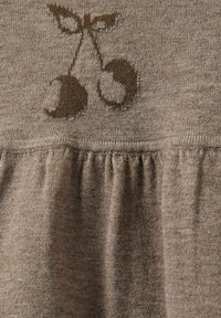 Smeđi pleteni top s dekorativnim motivom trešnje, teksturiranom tkaninom i nabrane rubove za dodatni oblik i interes.