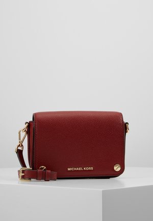 Red pebbled leather crossbody bag with gold-tone hardware and adjustable strap, featuring Michael Kors logo on front flap.