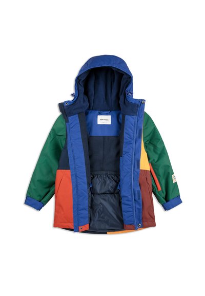 Veste colorée remplie de duvet avec une capuche bleue, des panneaux verts, orange, rouges et jaunes, fermeture éclair à l'avant et poignets élastiques. Doublure en polaire à l'intérieur.