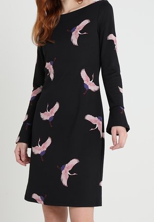 Robe noire à manches longues ornée de motifs colorés de grues, avec un col rond et des manches évasées, fabriquée dans un tissu doux et extensible.