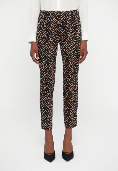Pantalones con un diseño de zigzag en negro y beige. Confeccionados en una tela suave, presentan un corte ajustado y piernas entalladas.