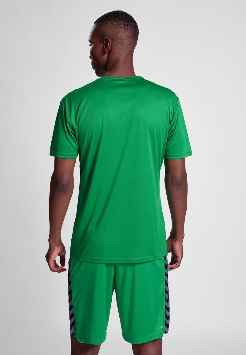 Zielony sportowy t-shirt wykonany z gładkiego, odprowadzającego wilgoć materiału, z krótkimi rękawami i okrągłym dekoltem, w połączeniu z dopasowanymi szortami.