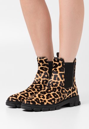 Bottines à motif léopard avec un dessus texturé, un panneau latéral élastique noir et une semelle en caoutchouc épaisse, offrant un look audacieux et contemporain.