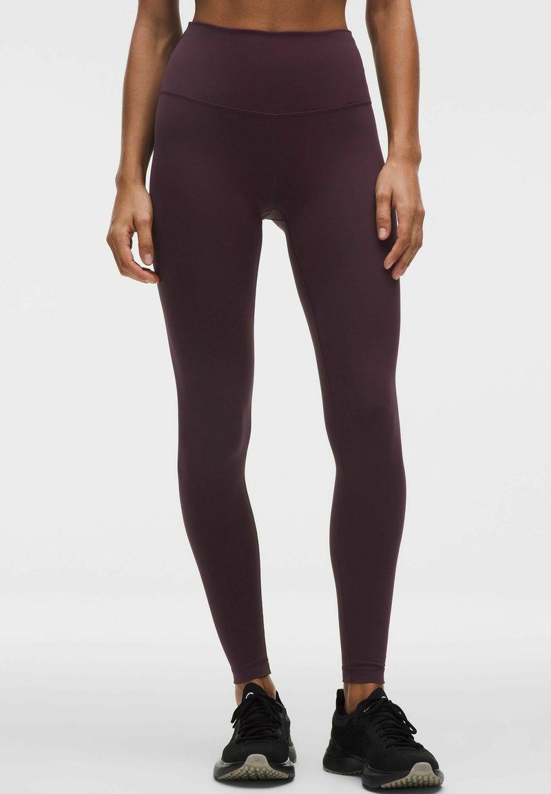 Bordeaux leggings med hög midja, tillverkade av mjukt och elastiskt tyg. Benen sitter tight mot kroppen, har en sömlös design och minimal detaljering.