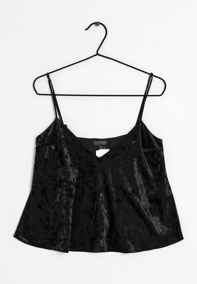 Svart sammetslinne med tunna justerbara band, V-ringning och utsvängd nederdel. Slät textur med lätt glans och etikett synlig inuti.