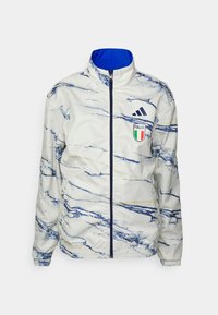Vit jacka med blå marmor mönster, dragkedjestängning, hög krage och blå innerfoder. Har Italiens emblem och Adidas-logotyp på bröstet.