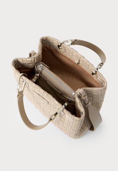 Μπεζ τσάντα tote με σχέδιο καπιτονέ, ανοιχτή εσωτερική όψη που δείχνει θήκη με φερμουάρ και ευρύχωρο διαμέρισμα, διπλές λαβές και αποσπώμενο ιμάντα ώμου.