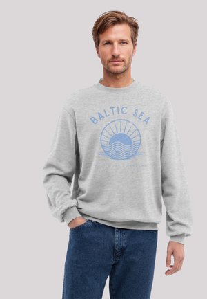 Light gray crewneck sweatshirt featuring a blue graphic print with "BALTIC SEA" and a sun and wave design. Soft fabric and ribbed cuffs.