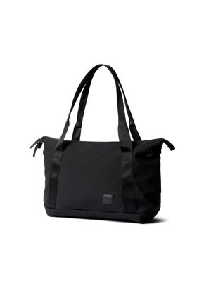 Borsa tote rettangolare nera con doppie maniglie lunghe, chiusura superiore con cerniera e piccola toppa con logo frontale, posata su sfondo bianco.