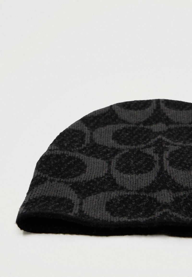 Zwarte gebreide beanie met een gladde textuur, voorzien van een geometrisch patroon van onderling verbonden cirkels in donkerdere tinten, met een omgeslagen rand.