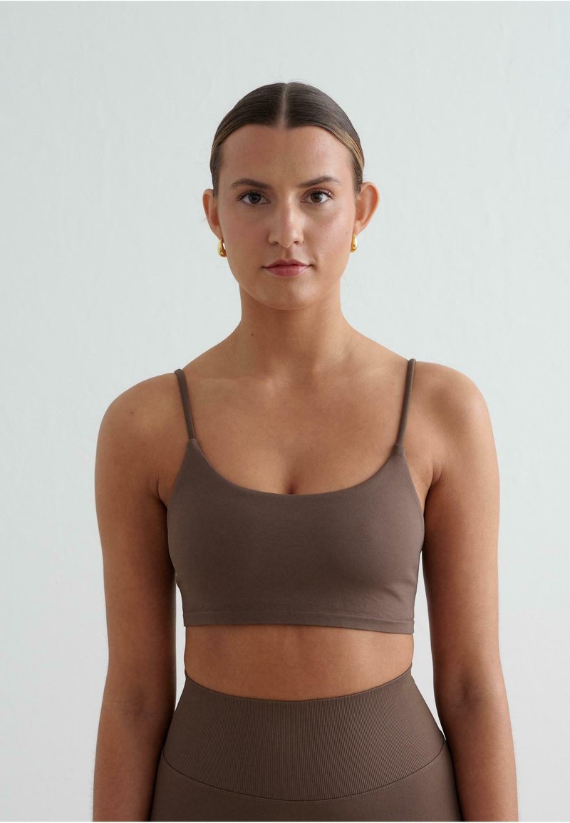 Bruine cropped tanktop met dunne bandjes, gemaakt van zachte stof. Gladde textuur met een aansluitend ontwerp, gecombineerd met hoge taille bijpassende bottoms.