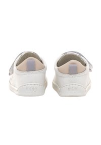 Zapatos de cuero blanco con forma redondeada, que cuentan con un suave acento gris en el talón y un cierre de gancho y bucle para facilitar su uso.