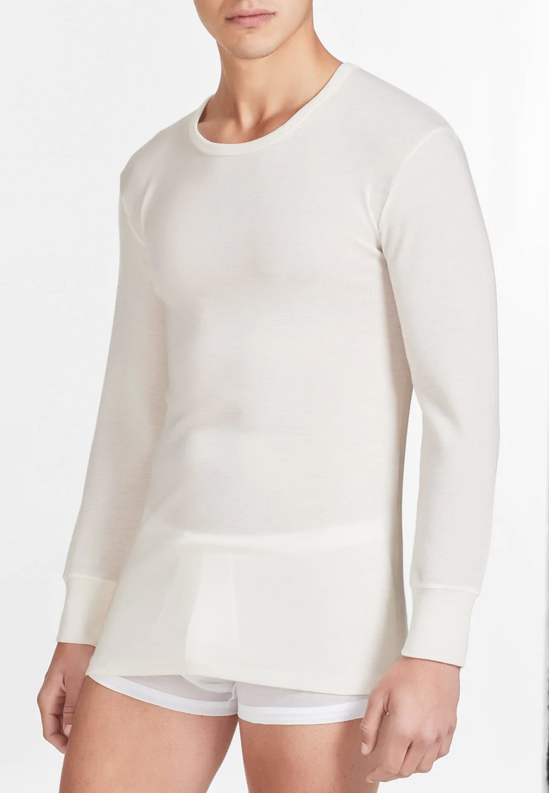 Maglietta termica a maniche lunghe in bianco sporco, realizzata in tessuto rigato leggero. Presenta un collo rotondo e una vestibilità aderente.