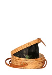 Borsa rotonda in paglia intrecciata con tracolla in pelle color tan e interno in tessuto nero con ricami floreali. Parte superiore aperta con chiusura sicura.