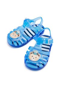 Sandalias de gel azul transparente con decoración de cara de oso, diseño abierto y suela a rayas. Correa ajustable para un ajuste seguro.