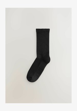 Zwarte geribde sokken met een gladde textuur, voorzien van een verstevigde teen en boord. Ontworpen voor een nauwsluitende pasvorm, geschikt voor casual gebruik.
