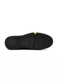 Semelle de chaussure en caoutchouc noir avec des motifs de texture antidérapants, comportant un accent circulaire près du centre et un point jaune au talon.