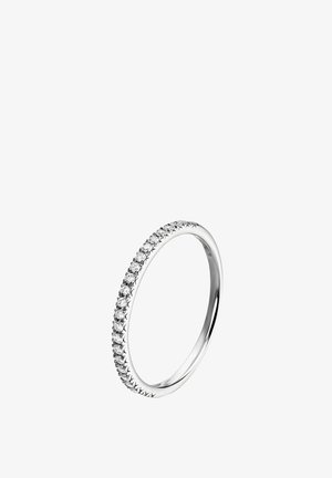 Anillo de plata con una banda delgada engastada con pequeñas piedras transparentes y redondas a lo largo del borde frontal, creando un aspecto brillante y continuo.