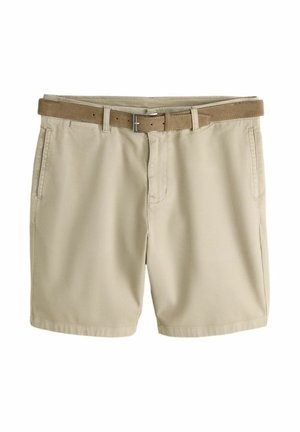 Beige chino shorts met voorzakken en een bruine leren riem door de riemlussen, plat neergelegd op een witte achtergrond.