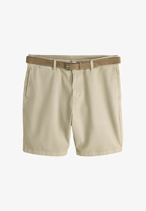 Beige chino shorts met voorzakken en een bruine leren riem door de riemlussen, plat neergelegd op een witte achtergrond.