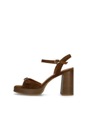 Bruine suède sandaal met hoge blokkadehak, enkelbandje met gesp en open teen met een kleine decoratieve gesp.
