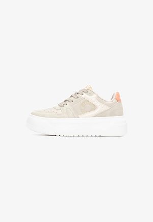 Zapatillas de ante beige con suela gruesa blanca, que presentan perforaciones, cordones beige y una lengüeta en la parte trasera de color naranja. Marca en el lateral.