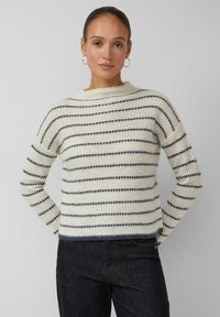 Strukturierter cremefarbener Pullover mit marineblauen Streifen, Rundhalsausschnitt und langen Ärmeln. Der untere Saum und die Bündchen sind mit einem gerippten Rand versehen.