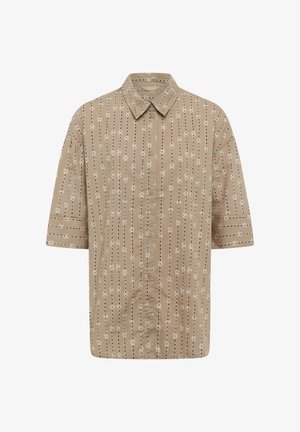 Lyhythihainen nappikiinnitteinen paita, jossa on pystysuuntainen mustavalkoinen kukkakuviollinen raita ja kaulus valkoisella taustalla.