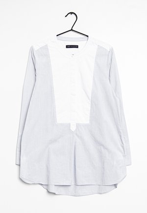 Långärmad skjorta med en vit frampanel och ljusblå randig tyg. Har en rundad fåll och knappstängning vid halsen.