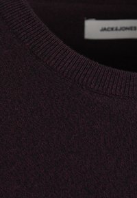 Suéter burdeos oscuro con cuello redondo acanalado, que presenta un patrón de tejido texturizado y una etiqueta que muestra "JACK & JONES."