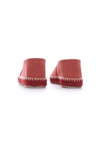 Scarpe slip-on in tela rossa con suola in juta intrecciata e cuciture bianche lungo il bordo. Forma arrotondata, design minimalista.
