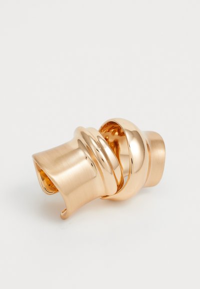 Agrafe de păr din metal cu ton auriu, cu o textură netedă, strălucitoare și mată, având un design răsucit. Formă curbată cu un sistem de prindere ergonomic.