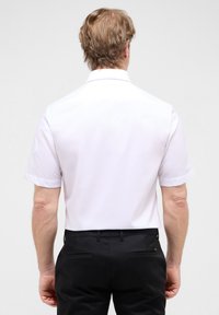 Witte korte mouwen shirt met een standaardkraag, gladde stof en een rechte snit, gecombineerd met zwarte broek met twee achterzakken.